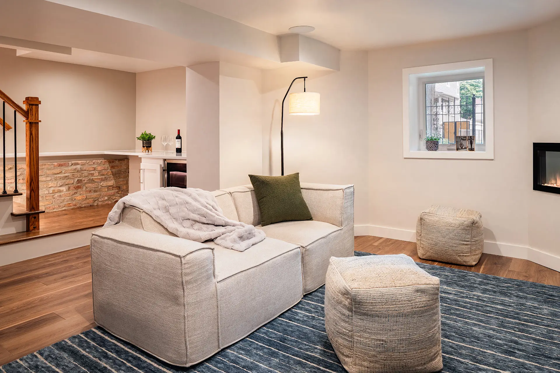 New basement family room space with open stairs and drybar beyond.