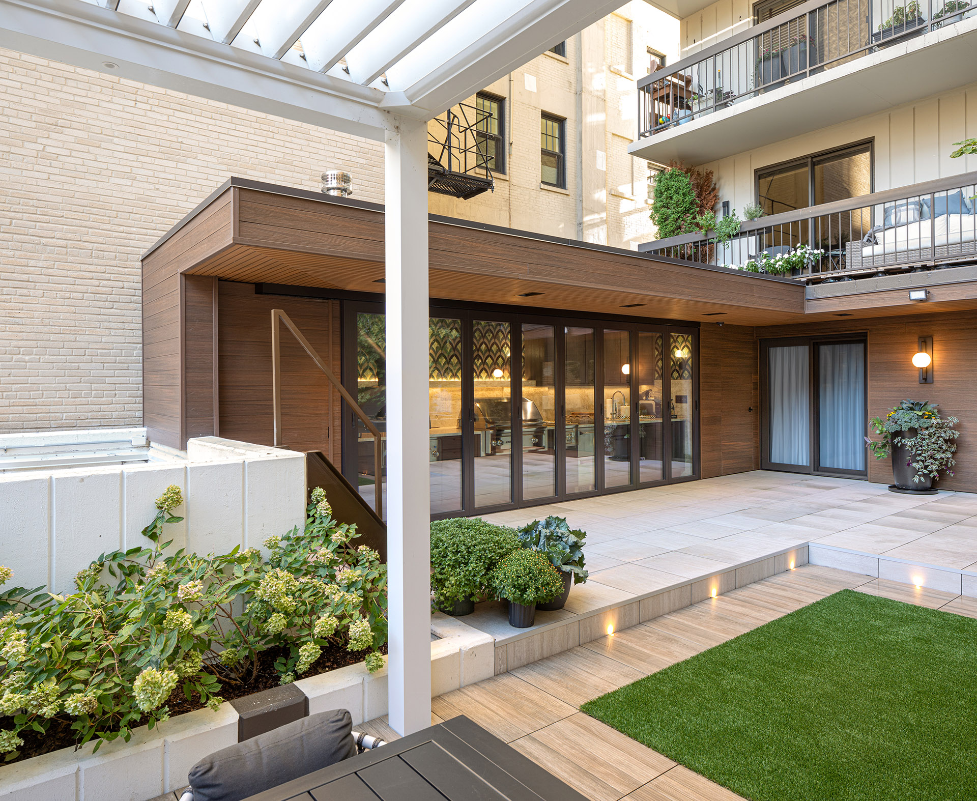 View of new outdoor kitchen with clad canopy from the pergola on the roof deck.